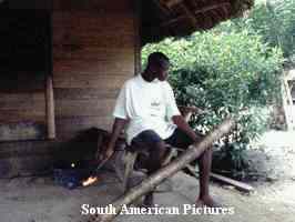 A Saramacca 'Bush Negro' using a gasoline vapour 'noise-maker'